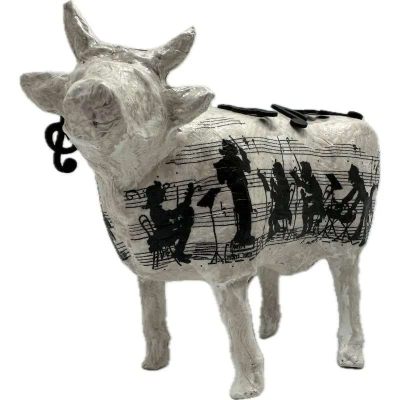Quelle vache décorative offrir à un musicien : statue en résine blanche ornée d'une partition et d'un ensemble de musiciens sur le flanc.
